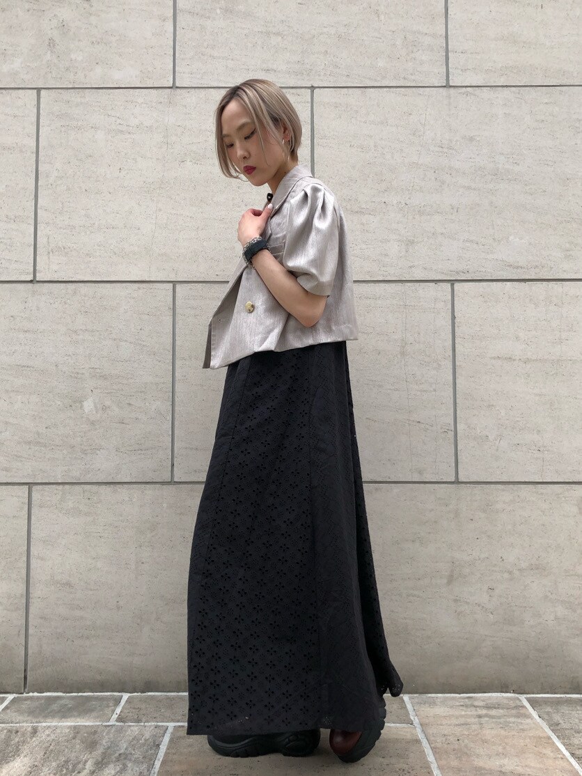 レッド系のブーツ、ホワイト系のセットアップ、ブラック系のワンピースを着用したレディースの春コーディネートの3枚目の写真