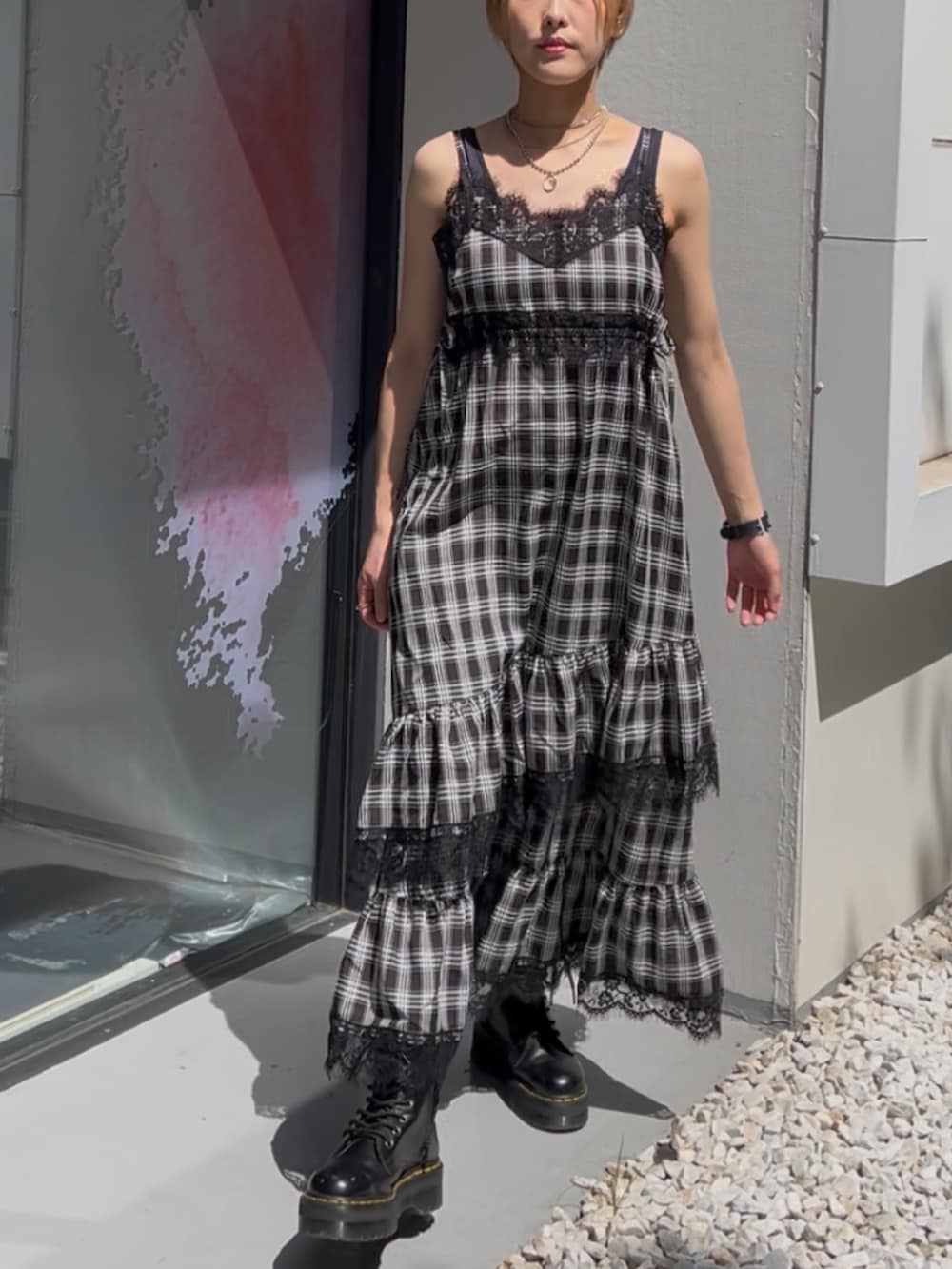 ブラック系のワンピース、ホワイト系のブルゾン、ブラック系のブーツを着用したレディースの夏コーディネートの7枚目の写真