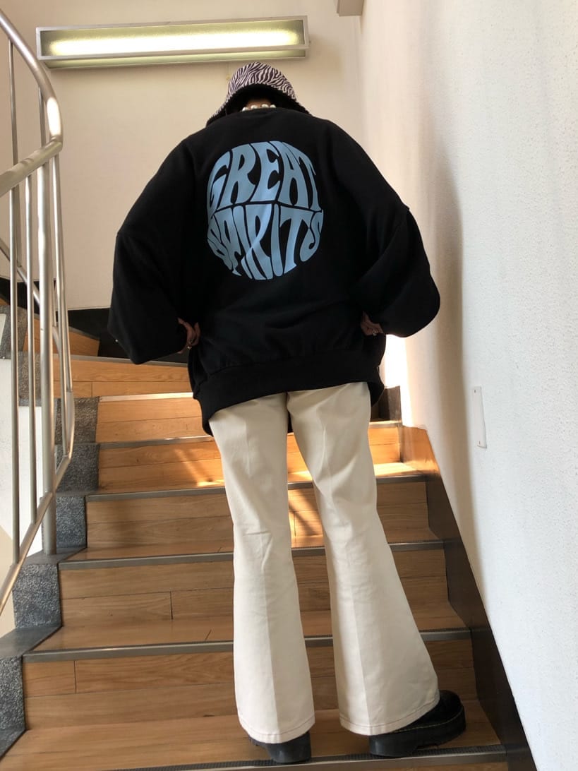 ホワイト系のデニムパンツ、ブラック系のスウェット、ブラック系のハットを着用したレディースの秋コーディネートの4枚目の写真