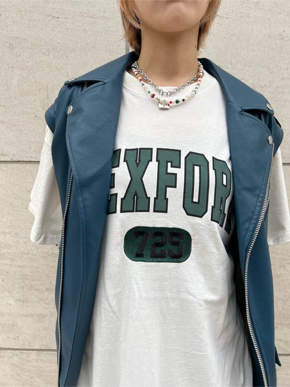 ブラック系のデニムパンツ、ホワイト系のTシャツ/カットソー、ブラック系のブーツを着用したレディースの秋コーディネートの8枚目の写真