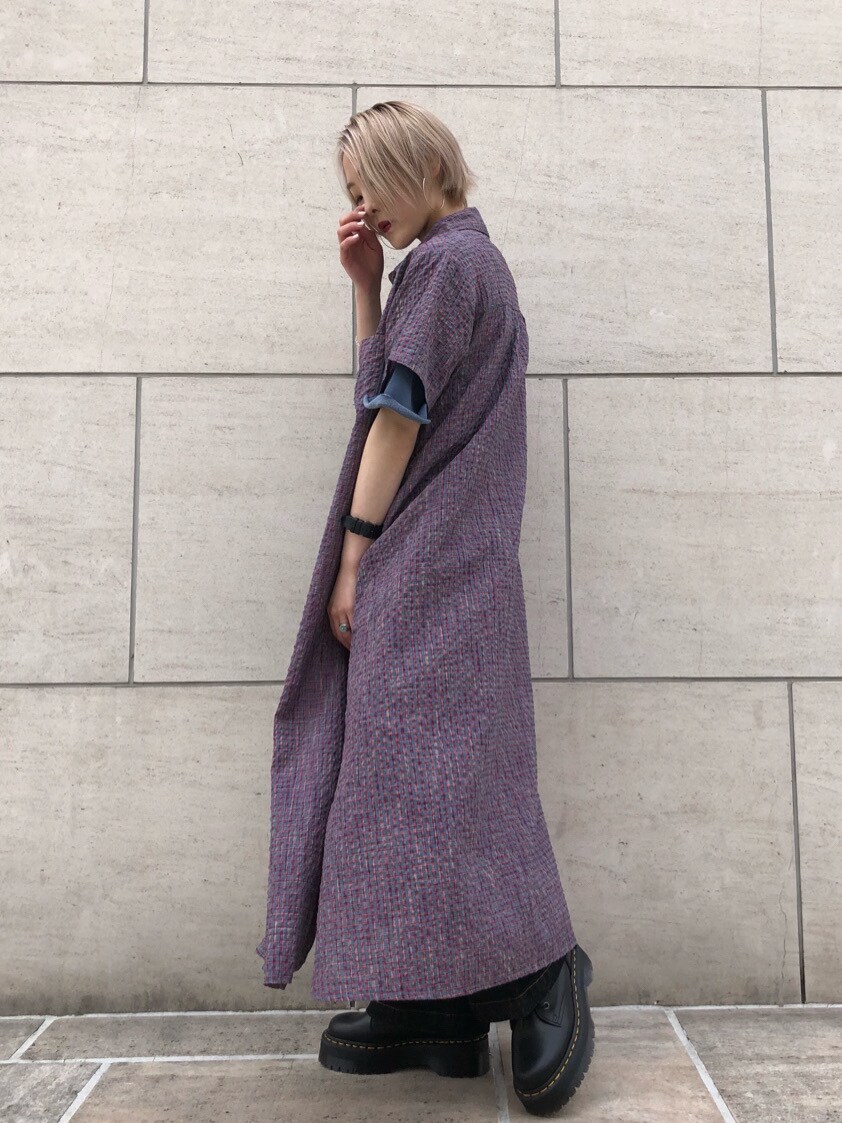 ブラック系のブーツ、ブルー系のワンピース、ブラック系のデニムパンツを着用したレディースの夏コーディネートの3枚目の写真