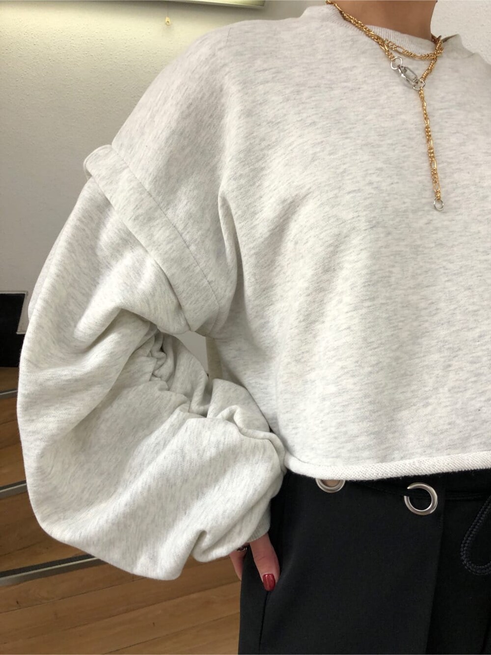 ブラック系のスラックス、グレー系のTシャツ/カットソー、ホワイト系のスニーカーを着用したレディースの冬コーディネートの5枚目の写真