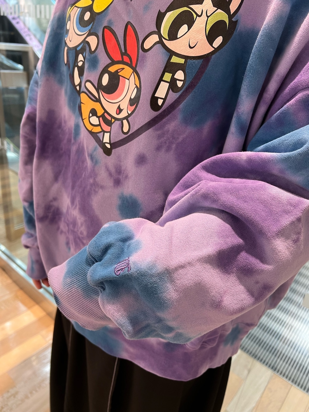 パープル系のスウェット、ブラック系のワンピース、ブラック系のローファーを着用したレディースの春コーディネートの8枚目の写真