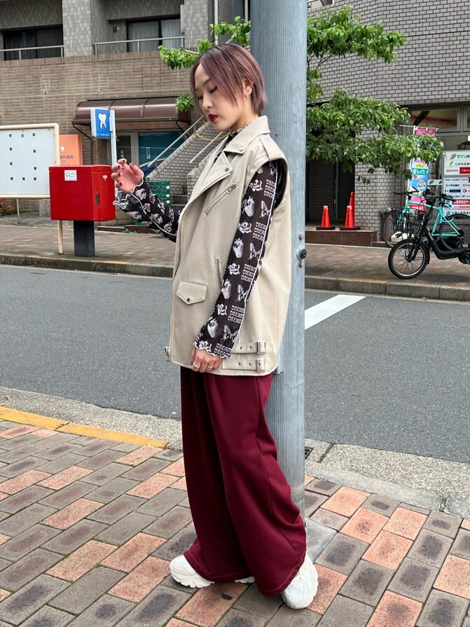 ブラック系のキャミソール、ホワイト系のスニーカー、ホワイト系のライダースジャケットを着用したレディースの秋コーディネートの2枚目の写真