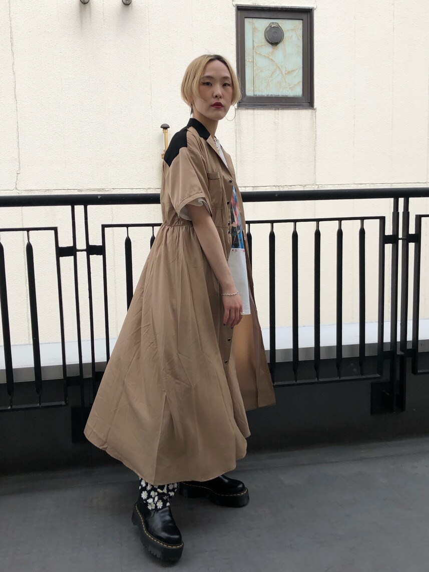 ブラック系のブーツ、パープル系のショルダーバッグ、ベージュ系のワンピースを着用したレディースの春コーディネートの5枚目の写真