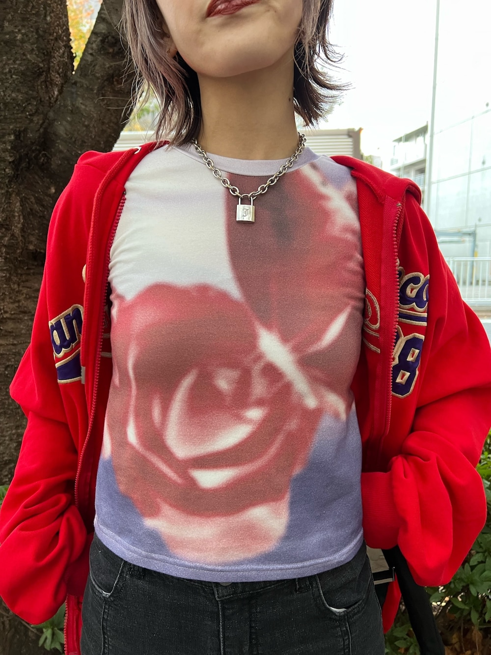 レッド系のパーカー、パープル系のTシャツ/カットソー、ブラック系のデニムパンツを着用したレディースの春コーディネートの7枚目の写真