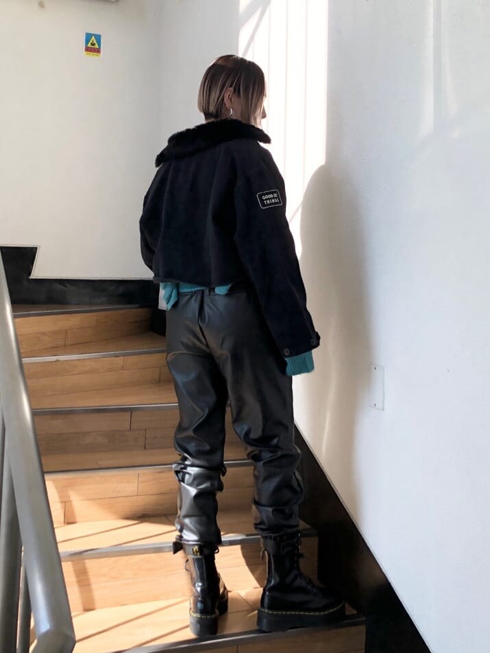 ブラック系のその他パンツ、ブラック系のミリタリージャケット、ブルー系のニット/セーターを着用したレディースの冬コーディネートの4枚目の写真