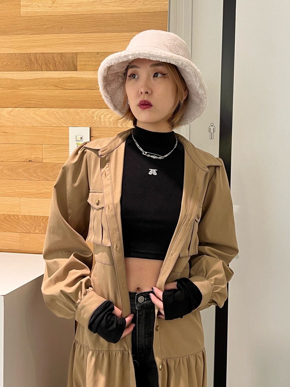 ブラック系のデニムパンツ、ブラック系のTシャツ/カットソー、ベージュ系のワンピースを着用したレディースの秋コーディネートの5枚目の写真