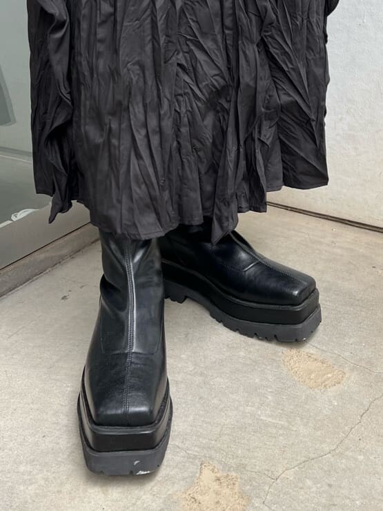 ブラック系のワンピース、ブラック系のTシャツ/カットソー、ブラック系のブーツを着用したレディースの秋コーディネートの9枚目の写真