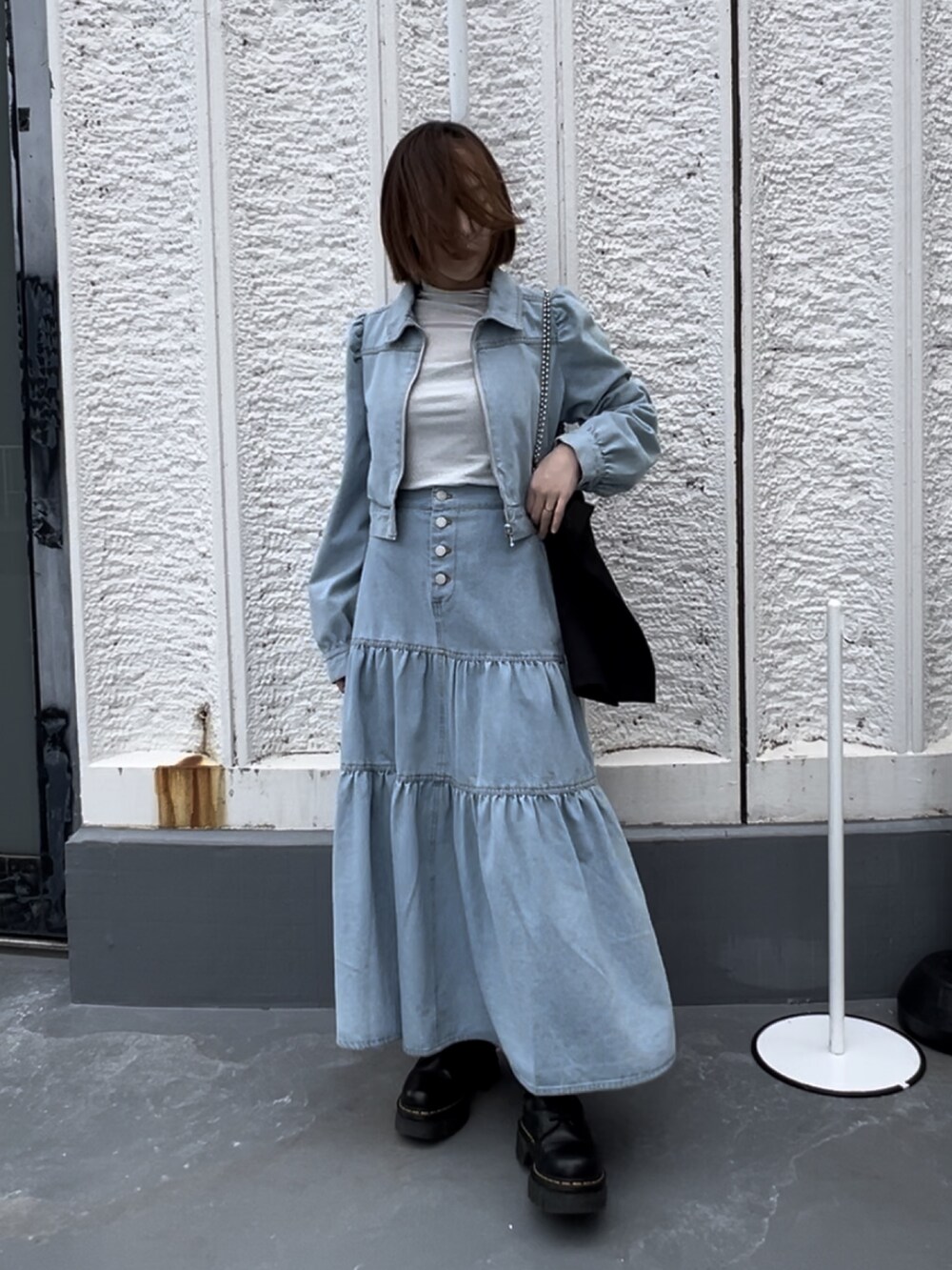 ブラック系のトートバッグ、シルバー系のTシャツ/カットソー、ブラック系のブーツを着用したレディースの春コーディネートの3枚目の写真