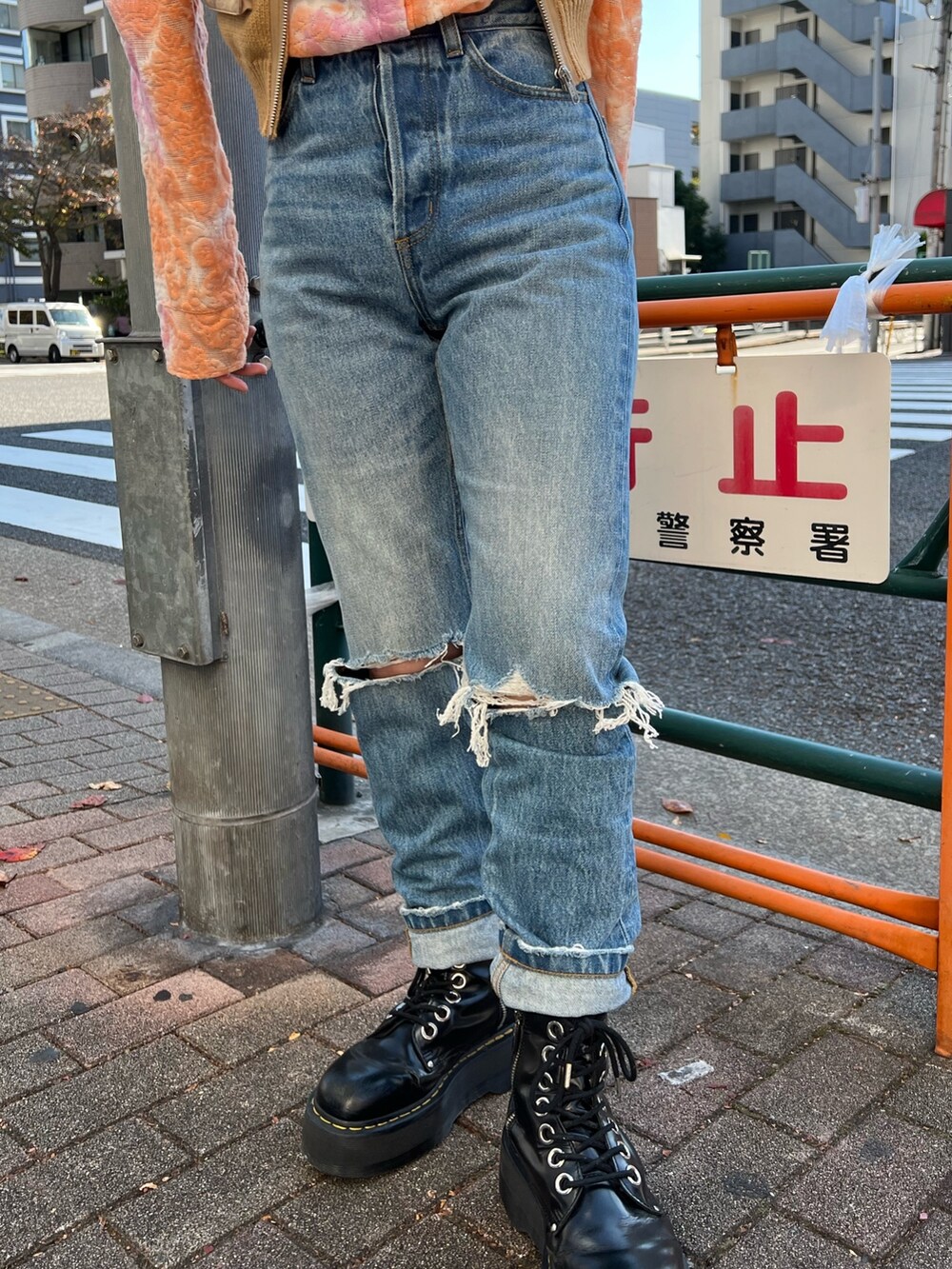 オレンジ系のシャツ/ブラウス、ベージュ系のベスト、ブルー系のデニムパンツを着用したレディースの春コーディネートの10枚目の写真