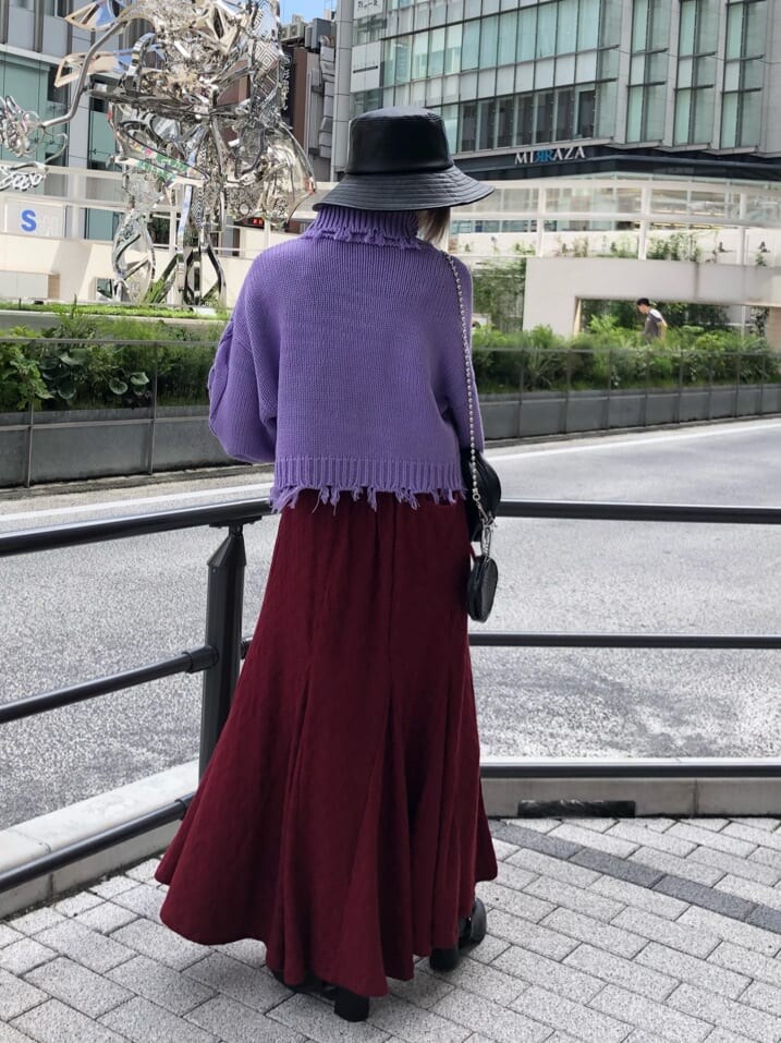 ブラック系のブーツ、ブラック系のショルダーバッグ、パープル系のニット/セーターを着用したレディースの秋コーディネートの3枚目の写真