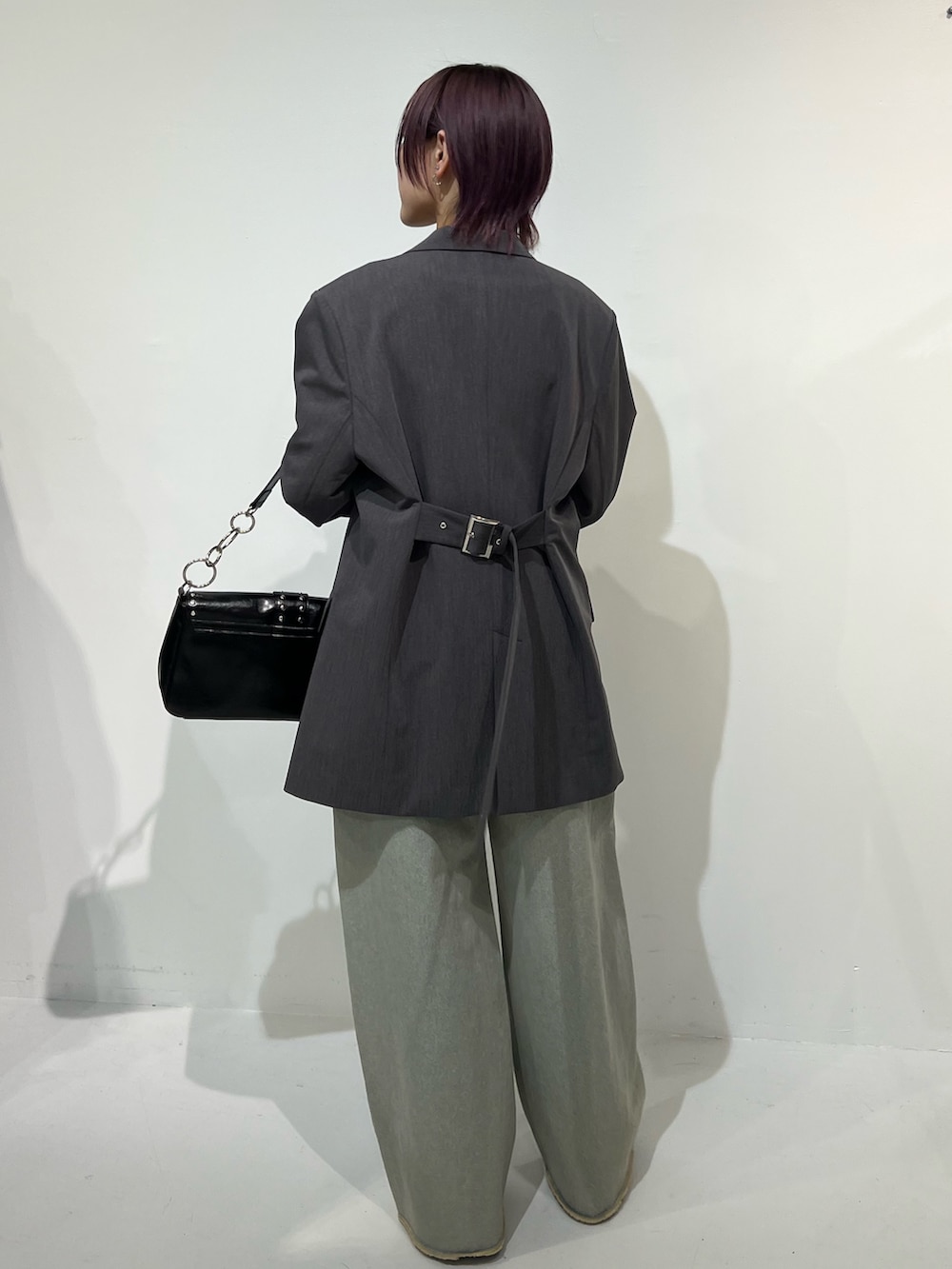 グレー系のテーラードジャケット、ブラック系のパンプス、ブルー系のデニムパンツを着用したレディースの春コーディネートの4枚目の写真