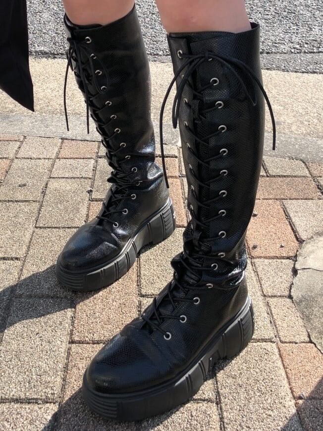 ブラック系のブーツ、ブラック系のトートバッグ、ブラック系のデニムパンツを着用したレディースの春コーディネートの8枚目の写真