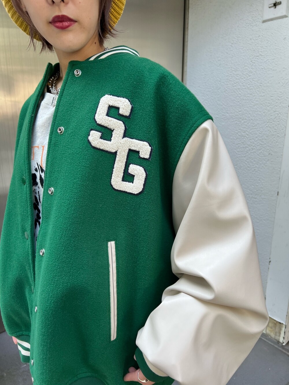 グレー系のスウェット、グリーン系のスタジャン、ホワイト系のスニーカーを着用したレディースの秋コーディネートの7枚目の写真