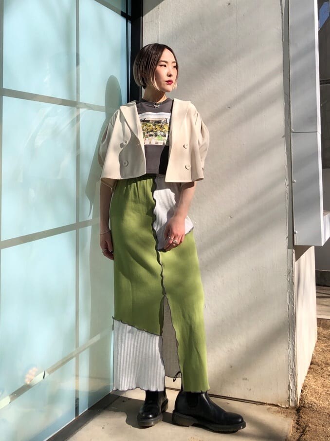 ホワイト系のテーラードジャケット、グリーン系のスカート、ブラック系のTシャツ/カットソーを着用したレディースの春コーディネートの5枚目の写真