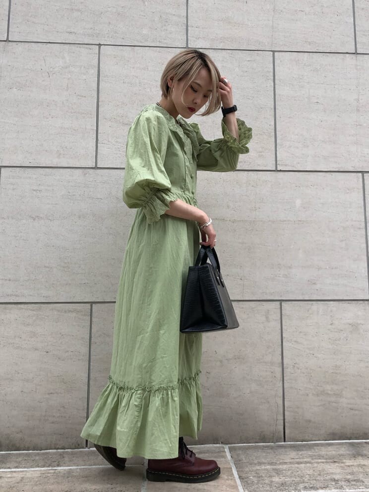 ブラック系のハンドバッグ、グリーン系のワンピース、シルバー系のチョーカーを着用したレディースの夏コーディネートの2枚目の写真