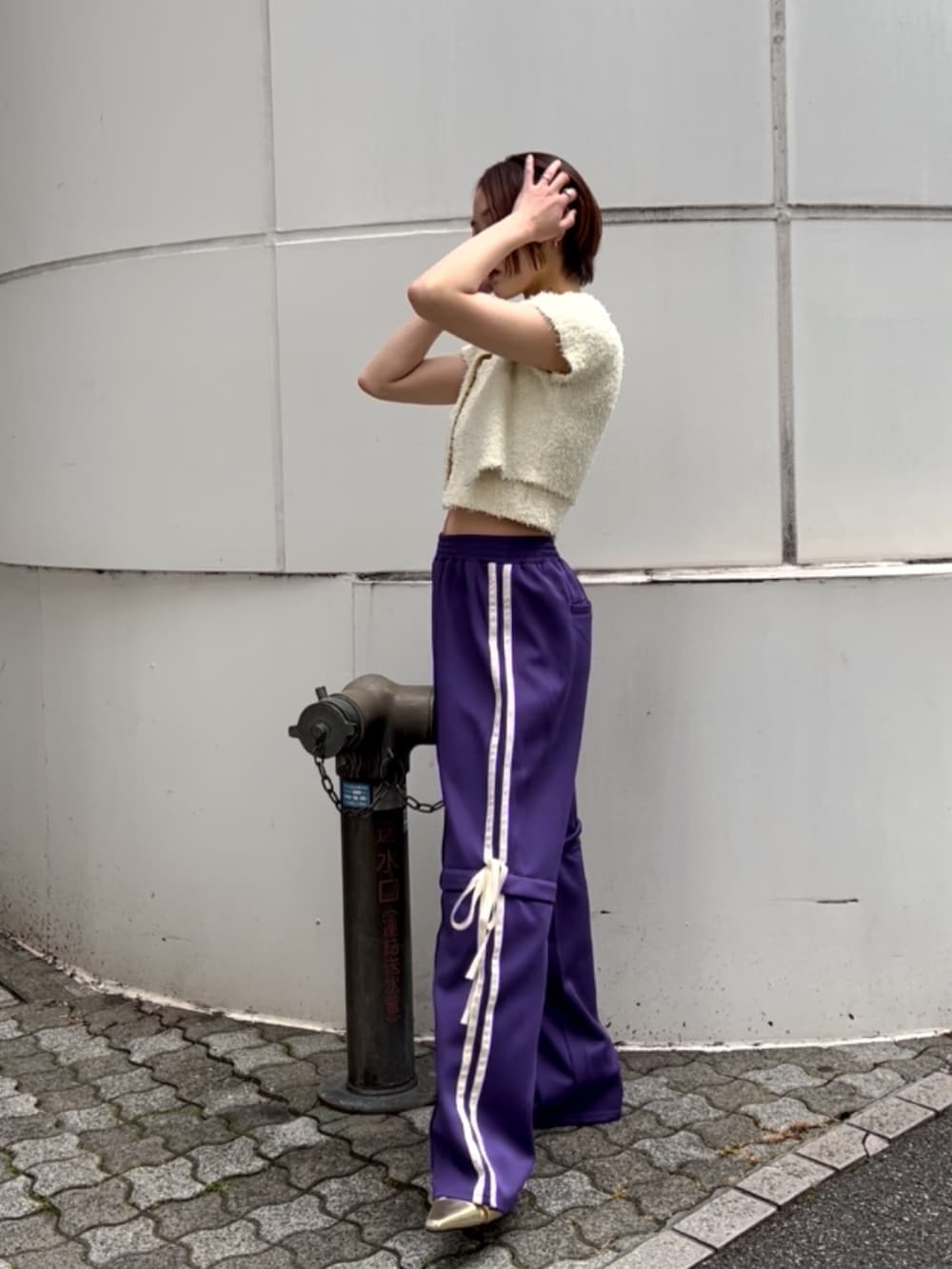 ホワイト系のアンサンブル、パープル系のその他パンツ、ゴールド系のパンプスを着用したレディースの夏コーディネートの3枚目の写真