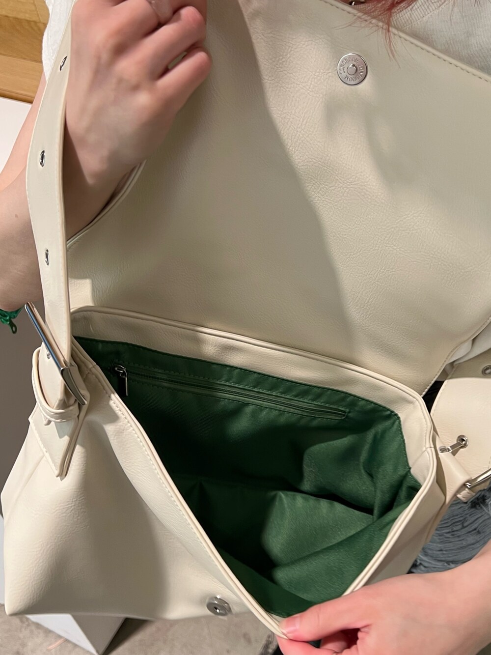 ホワイト系のタンクトップ、グリーン系のワンピース、ホワイト系のメッセンジャーバッグを着用したレディースの春コーディネートの10枚目の写真