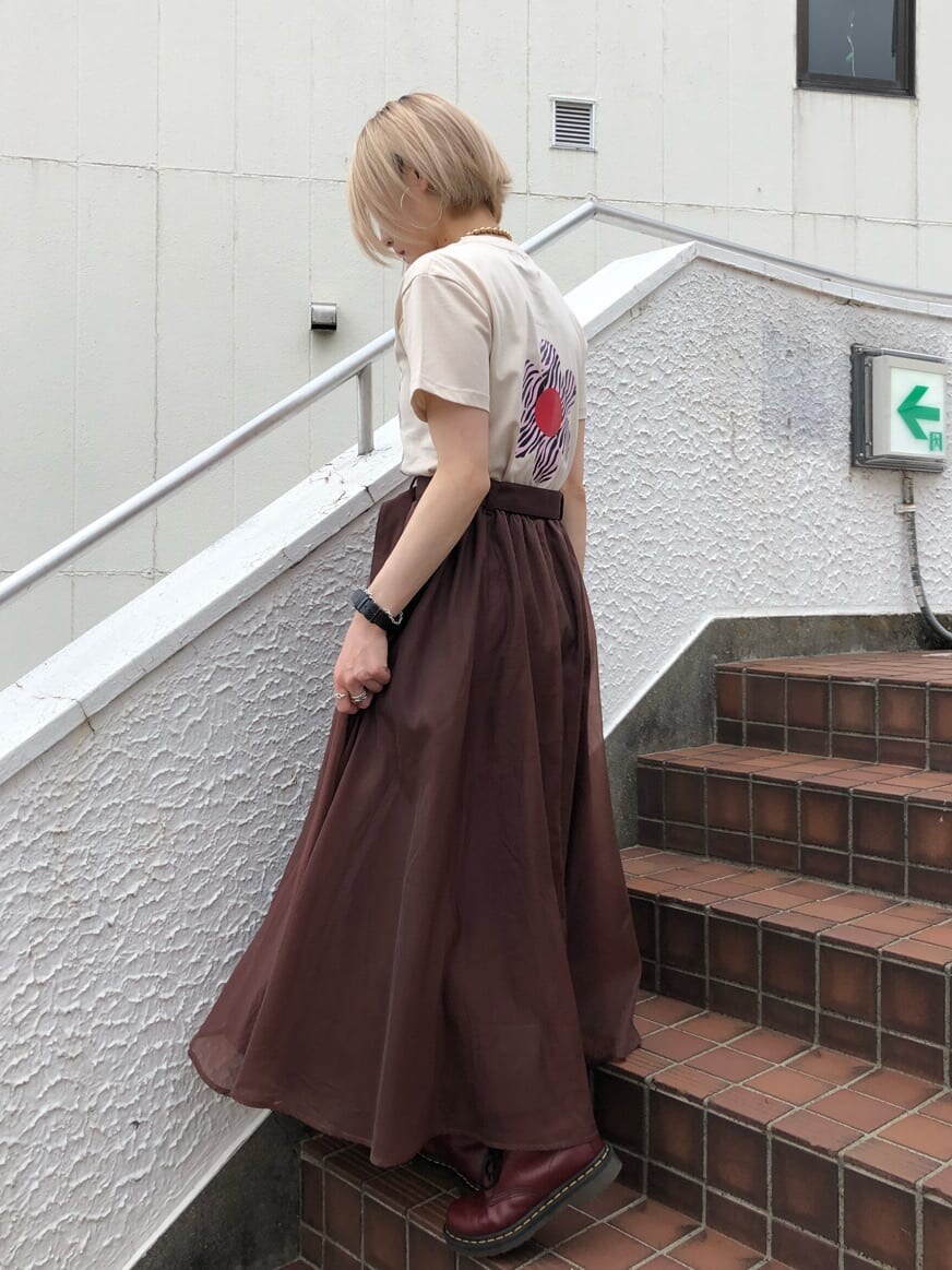 ブラウン系のスカート、ホワイト系のTシャツ/カットソー、ゴールド系のチョーカーを着用したレディースの夏コーディネートの3枚目の写真