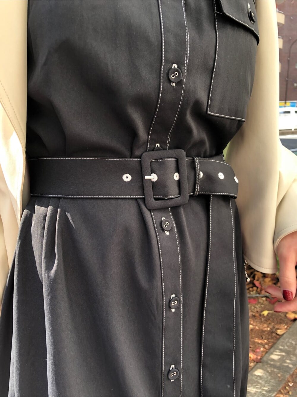 ホワイト系のライダースジャケット、ブラック系のワンピース、ホワイト系のショルダーバッグを着用したレディースの冬コーディネートの6枚目の写真