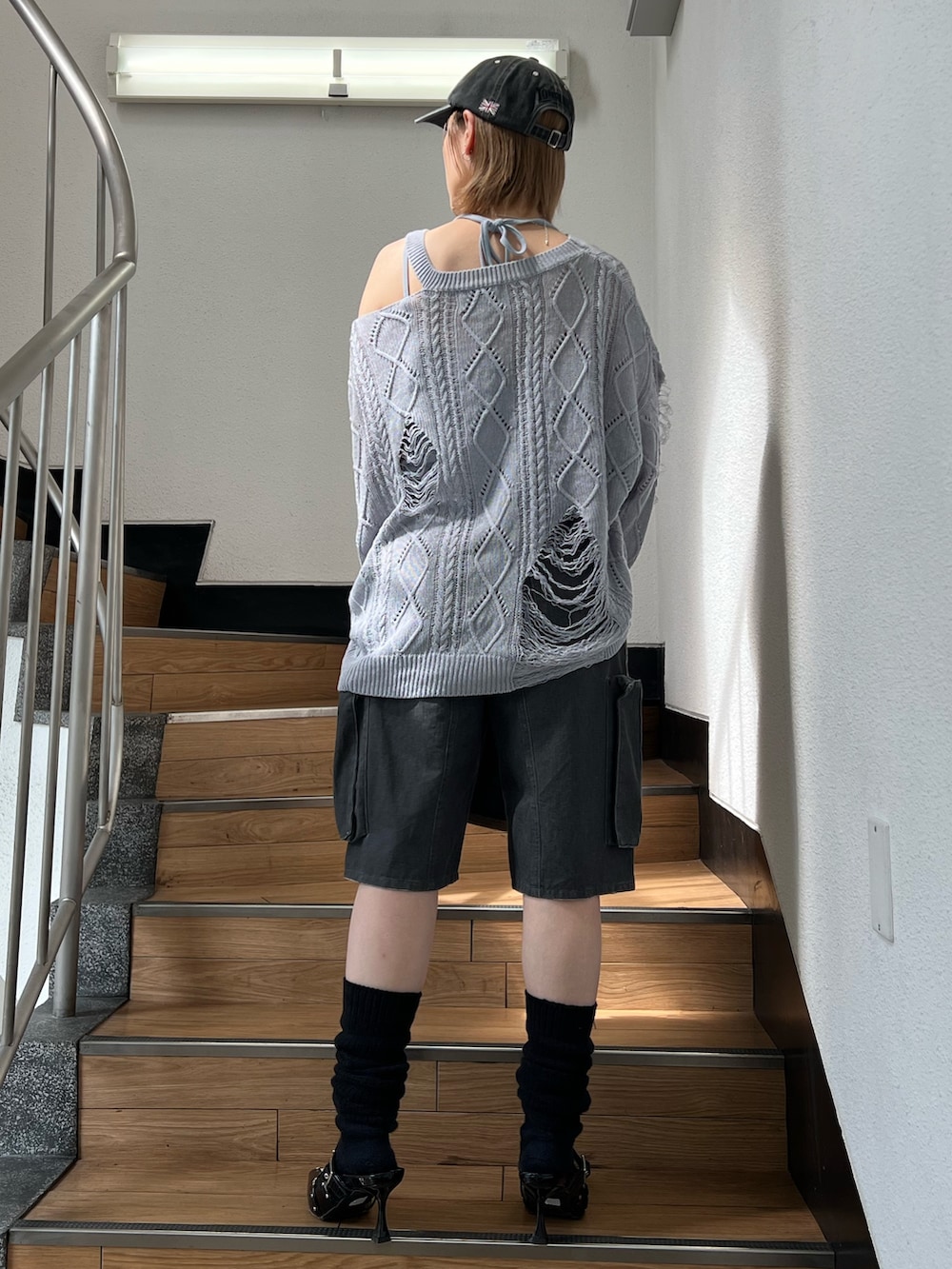 ブラック系のパンプス、ブラック系のカーゴパンツ、ブルー系のキャミソールを着用したレディースの春コーディネートの4枚目の写真