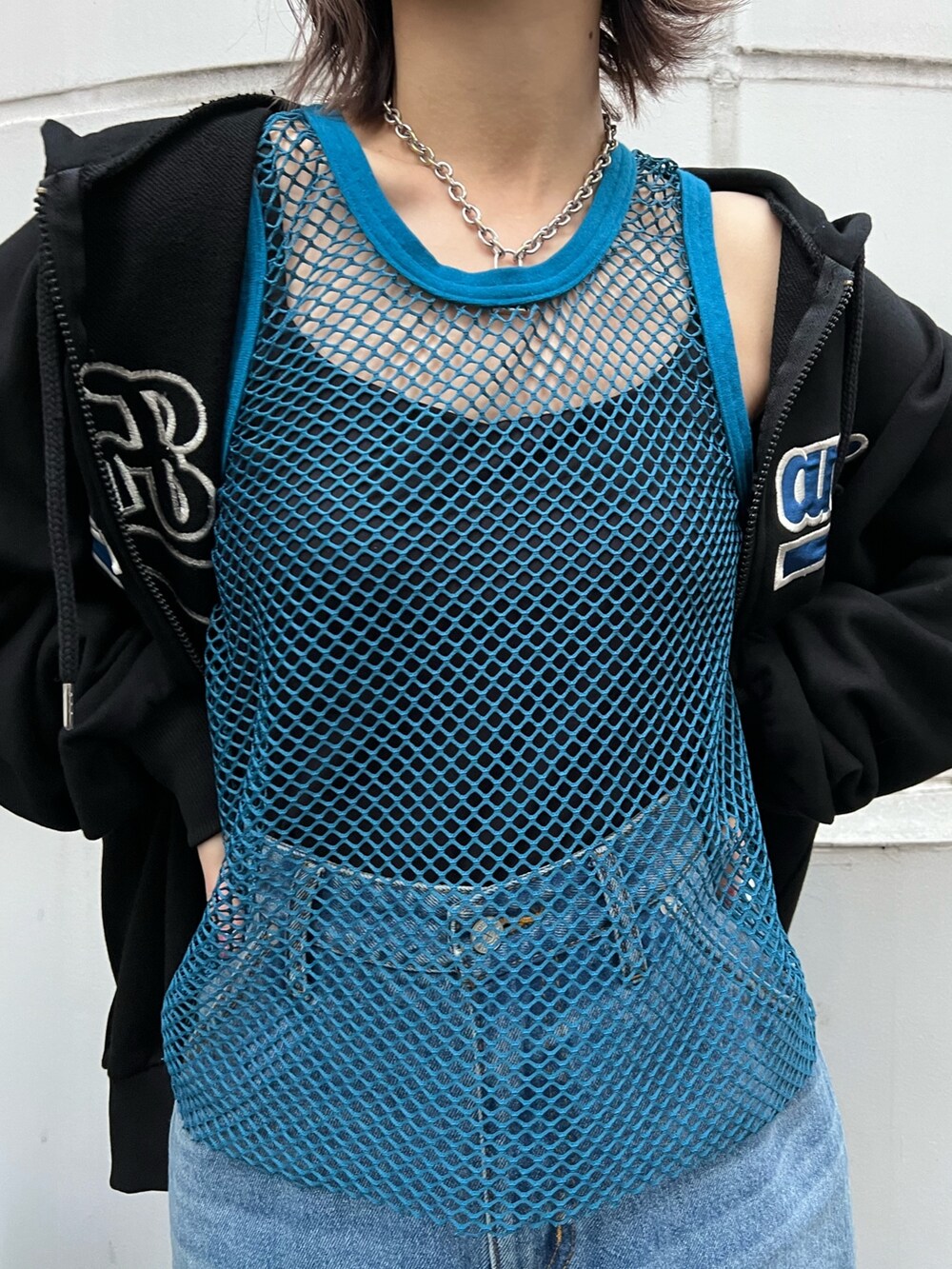 ブルー系のスカート、ブラック系のパーカー、ブルー系のタンクトップを着用したレディースの春コーディネートの9枚目の写真