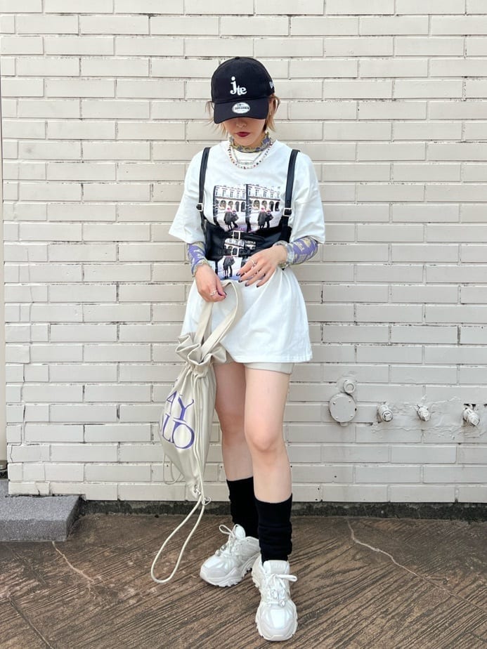 ホワイト系のスニーカー、ホワイト系のバックパック/リュック、ホワイト系のTシャツ/カットソーを着用したレディースの秋コーディネートの2枚目の写真