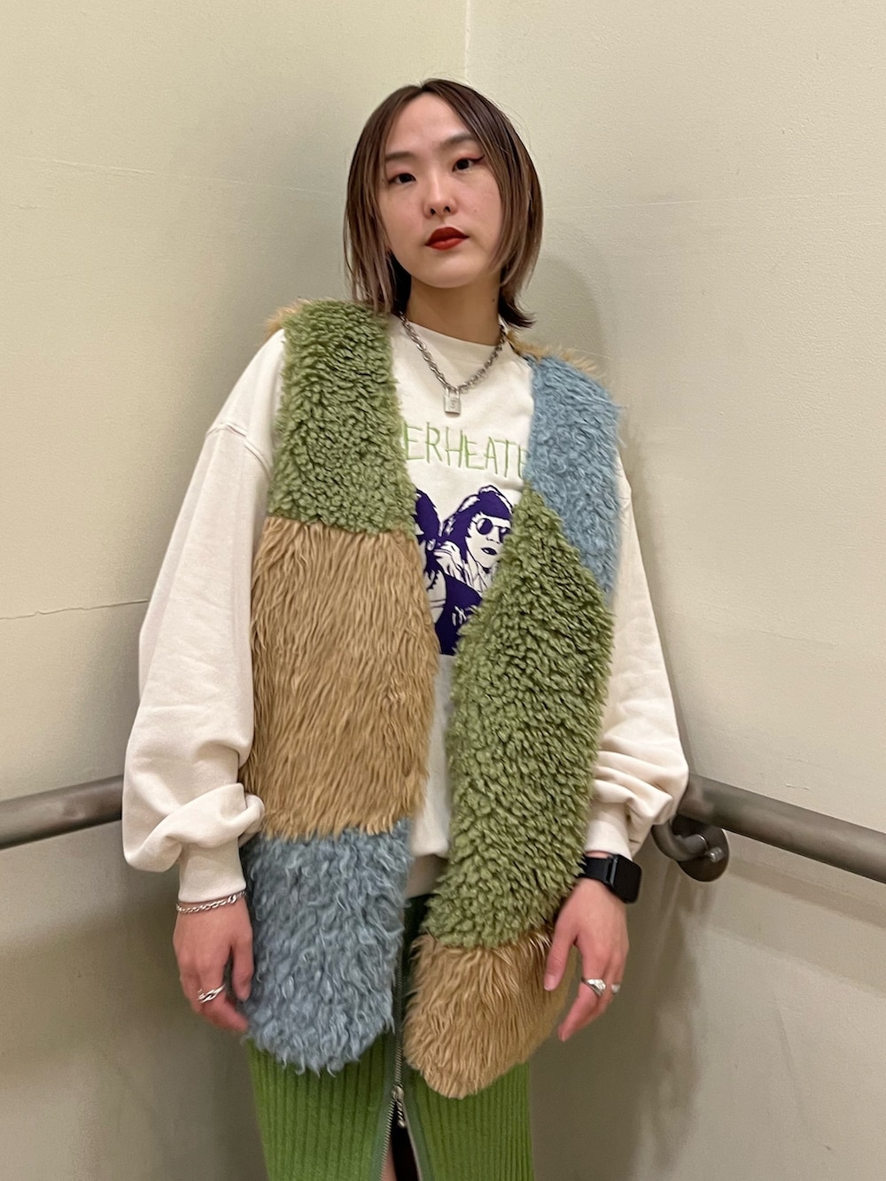 その他のベスト、ホワイト系のニット/セーター、グリーン系のスカートを着用したレディースの冬コーディネートの4枚目の写真