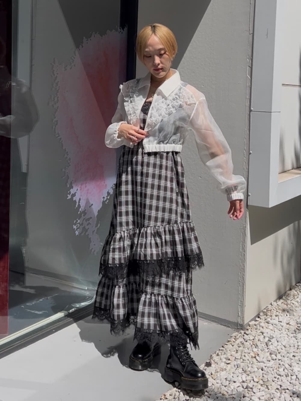 ブラック系のワンピース、ホワイト系のブルゾン、ブラック系のブーツを着用したレディースの夏コーディネートの3枚目の写真