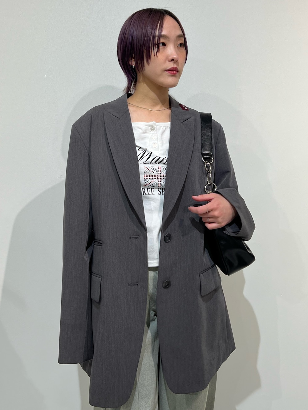 グレー系のテーラードジャケット、ブラック系のパンプス、ブルー系のデニムパンツを着用したレディースの春コーディネートの5枚目の写真