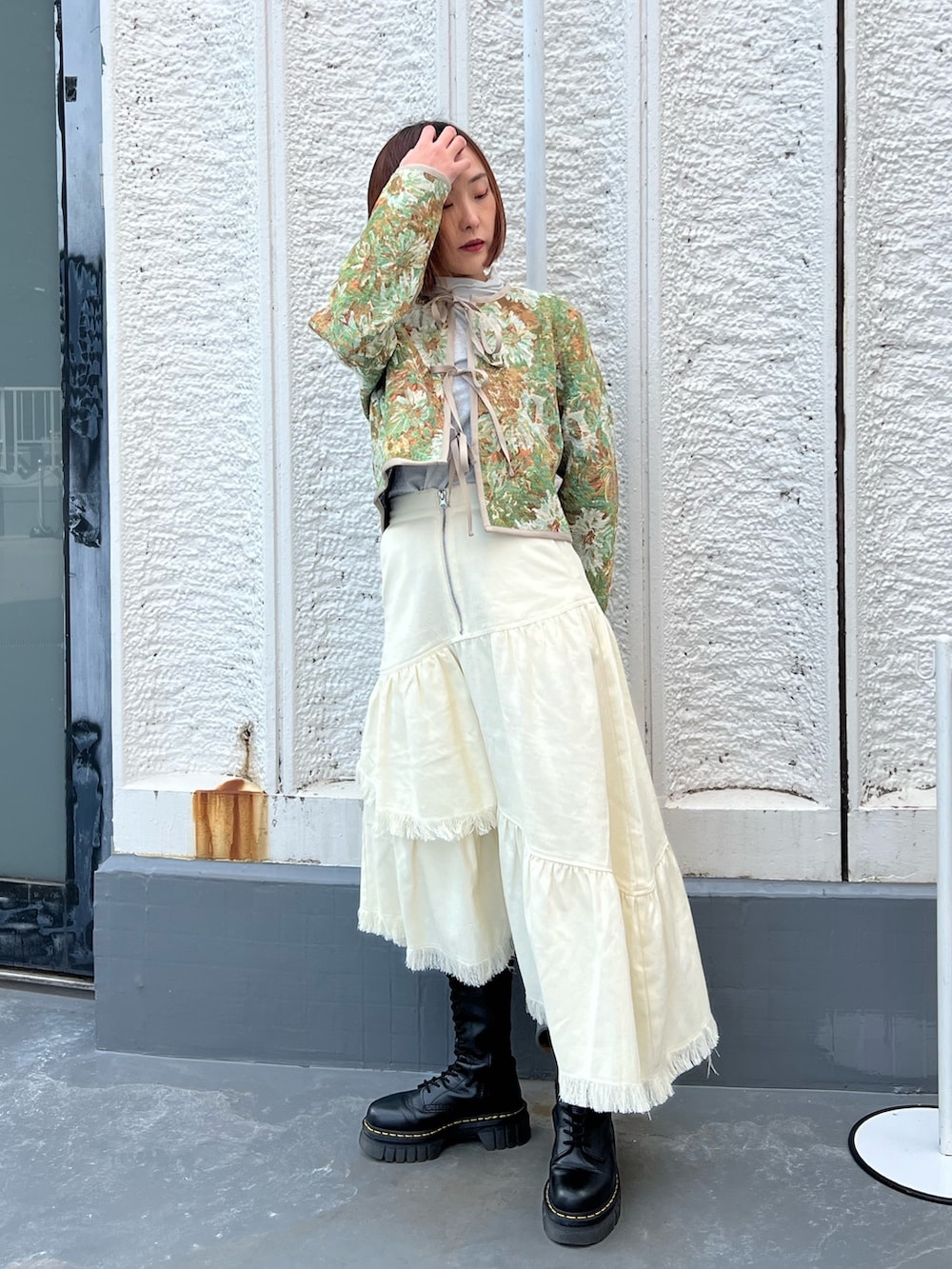 ブルー系のノーカラージャケット、ホワイト系のスカート、シルバー系のTシャツ/カットソーを着用したレディースの春コーディネートの2枚目の写真