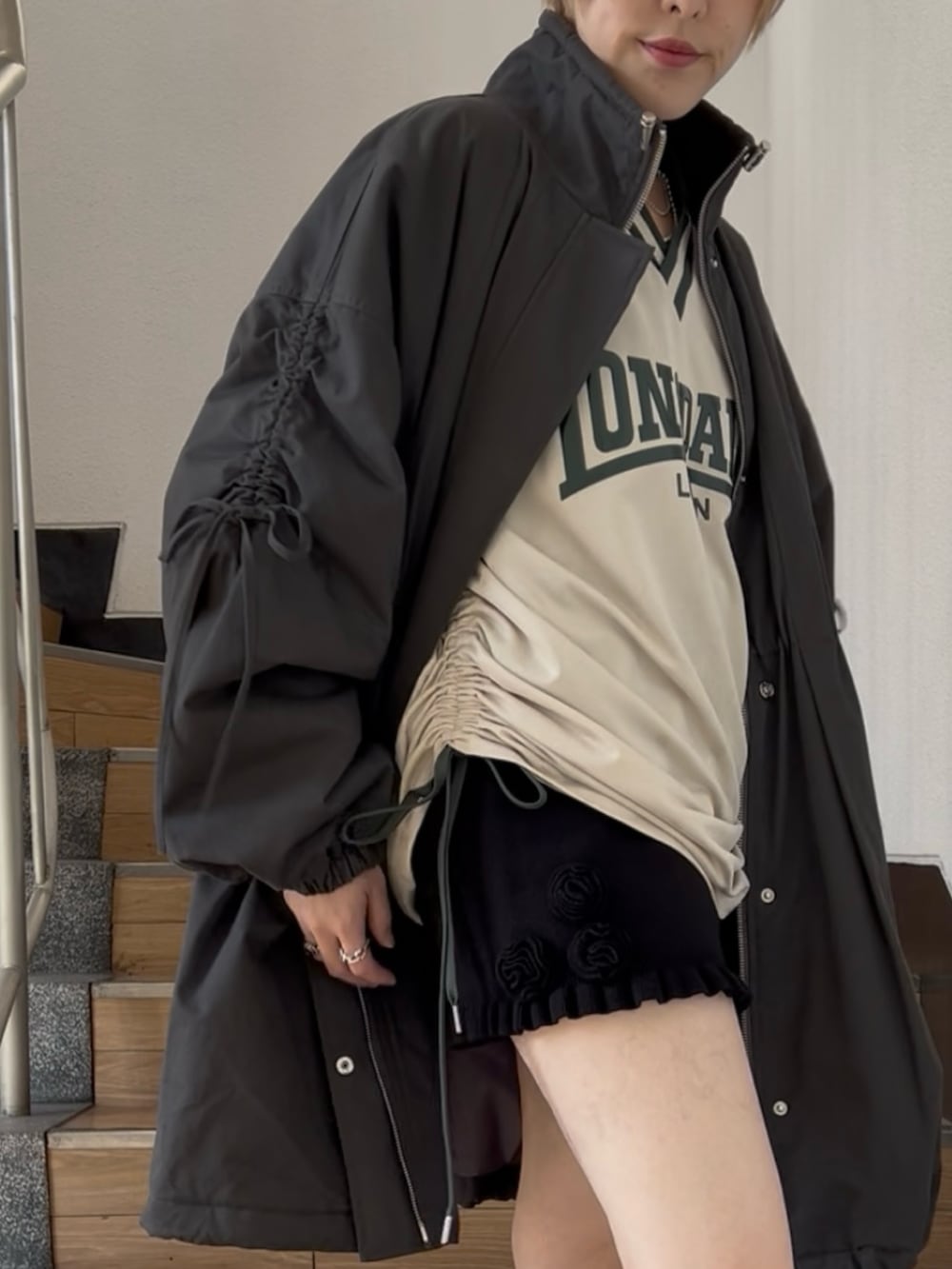 ブラック系のモッズコート、ホワイト系のTシャツ/カットソー、ブラック系のその他パンツを着用したレディースの夏コーディネートの3枚目の写真