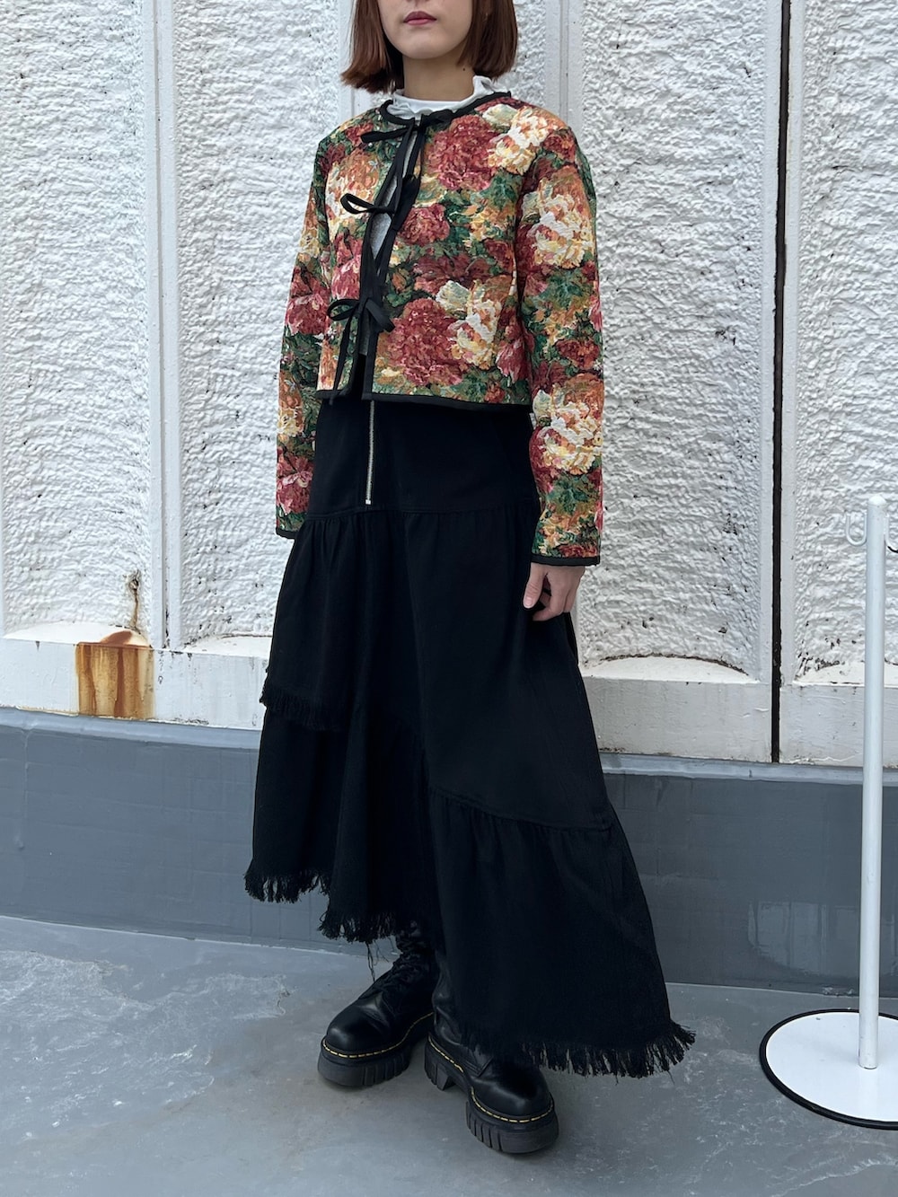 ブルー系のノーカラージャケット、ホワイト系のスカート、シルバー系のTシャツ/カットソーを着用したレディースの春コーディネートの4枚目の写真