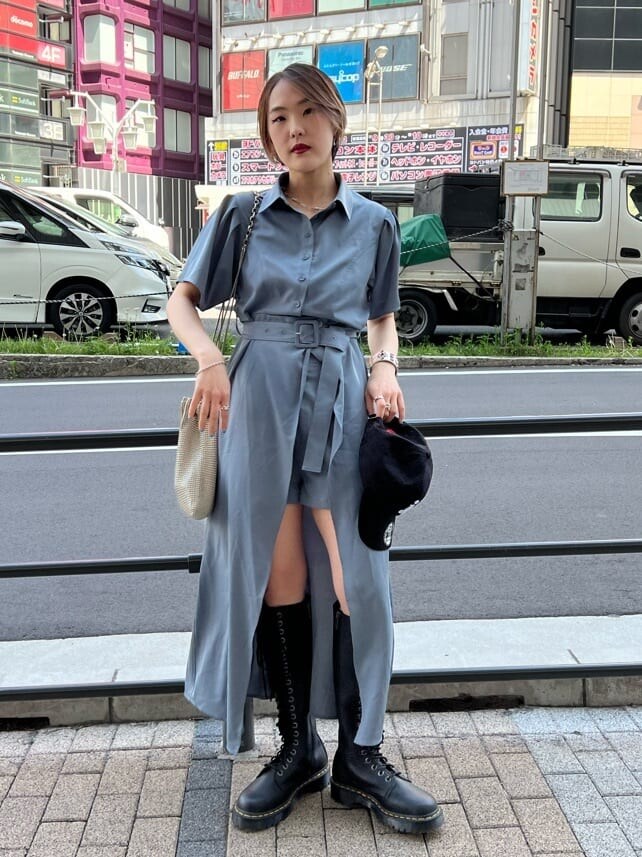 ブラック系のブーツ、グレー系のワンピース、ブラック系のキャップを着用したレディースの夏コーディネートの2枚目の写真