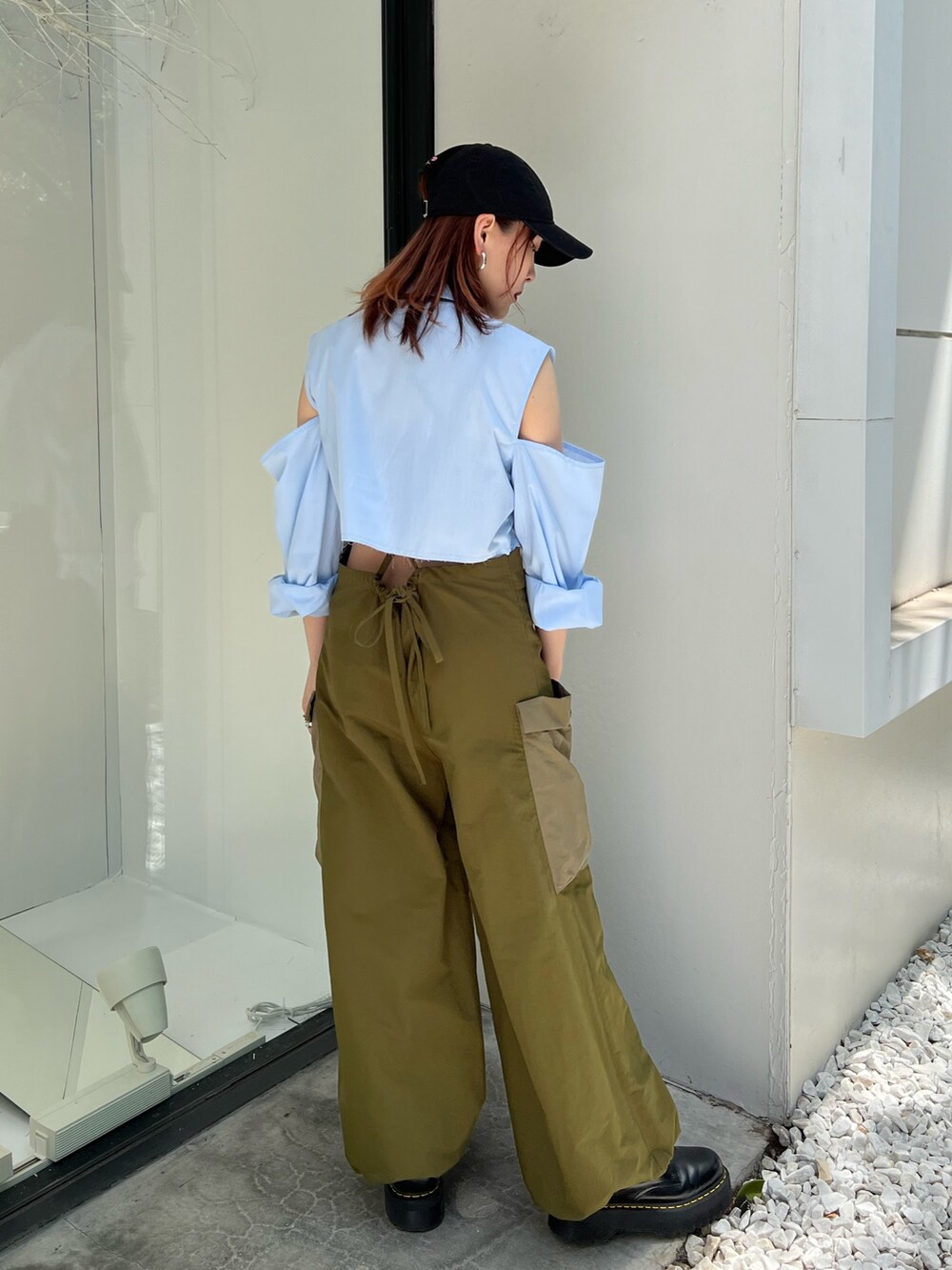 グリーン系のサロペット/オーバーオール、ブルー系のシャツ/ブラウス、ブラック系のキャップを着用したレディースの夏コーディネートの3枚目の写真