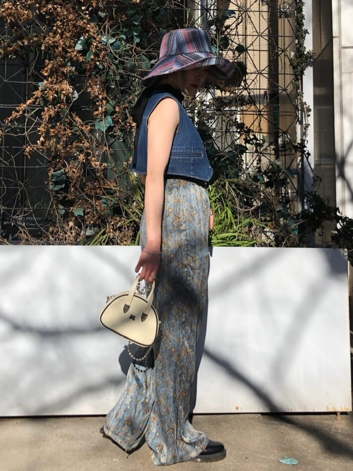 ブルー系のベスト、ブラック系のキャミソール、ホワイト系のボストンバッグを着用したレディースの夏コーディネートの2枚目の写真