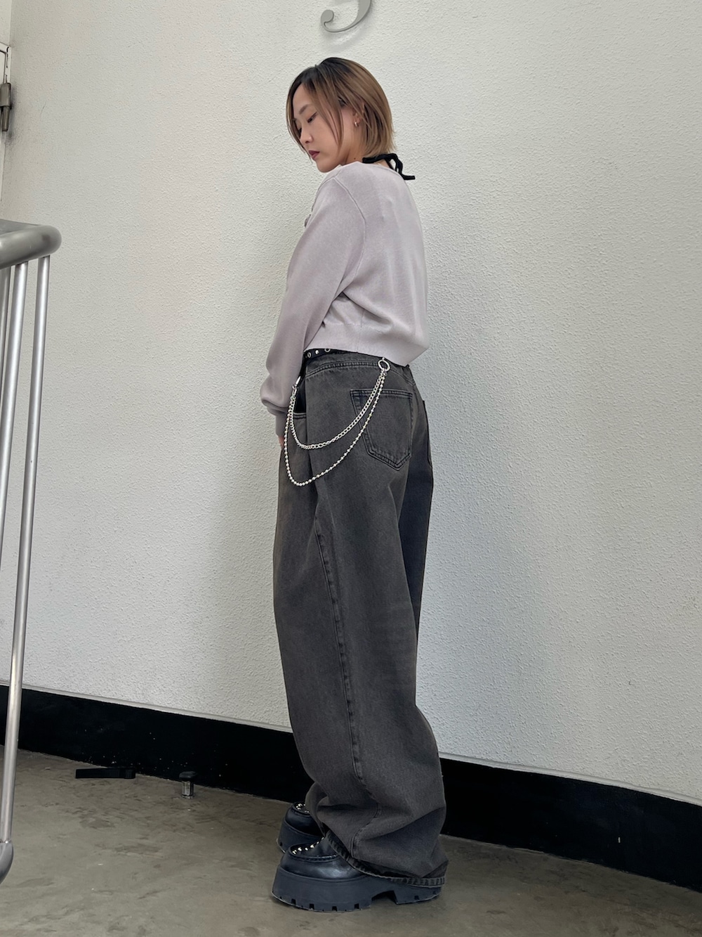 グレー系のニット/セーター、ブラック系のキャミソール、ブラック系のデニムパンツを着用したレディースの春コーディネートの2枚目の写真