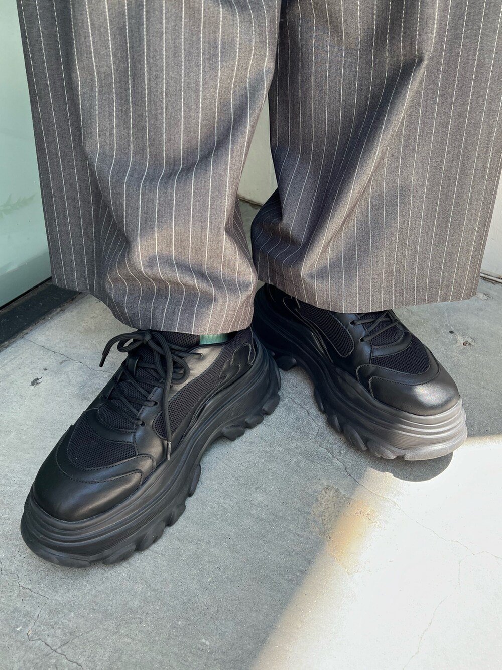 ホワイト系のポロシャツ、グレー系のスラックス、ブラック系のショルダーバッグを着用したレディースの夏コーディネートの8枚目の写真