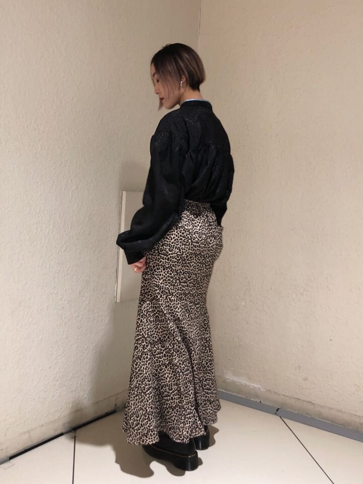 ブラック系のシャツ/ブラウス、ブラウン系のスカート、ブラック系のブーツを着用したレディースの春コーディネートの2枚目の写真