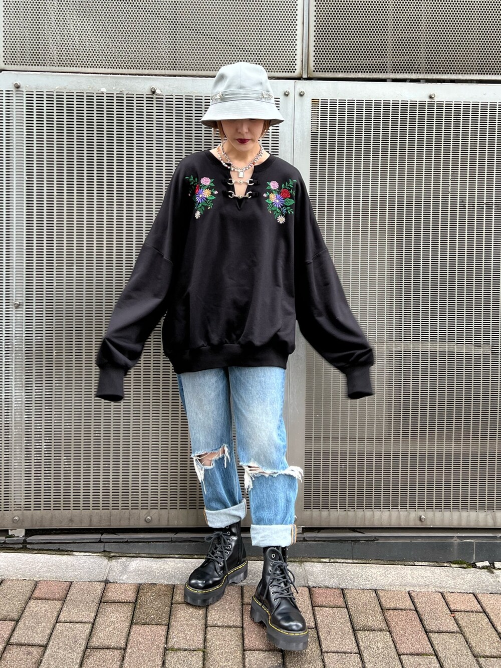 ブラック系のTシャツ/カットソー、ブルー系のデニムパンツ、ブラック系のブーツを着用したレディースの秋コーディネートの5枚目の写真