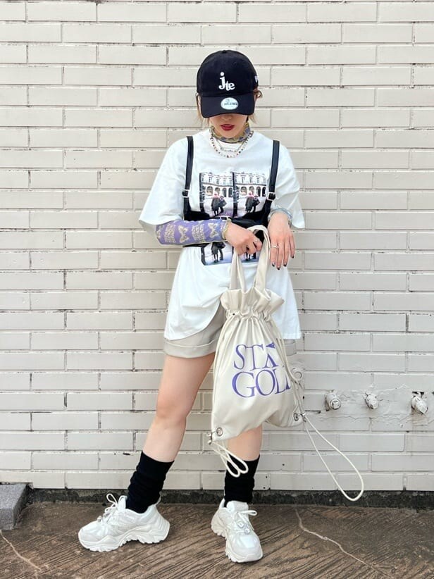 ホワイト系のスニーカー、ホワイト系のバックパック/リュック、ホワイト系のTシャツ/カットソーを着用したレディースの秋コーディネートの6枚目の写真