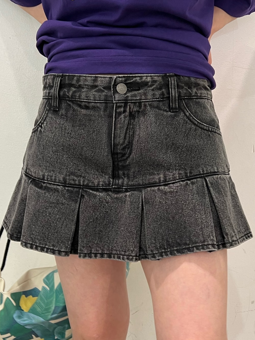 ブラック系のデニムパンツ、パープル系のTシャツ/カットソー、ホワイト系のショルダーバッグを着用したレディースの春コーディネートの7枚目の写真