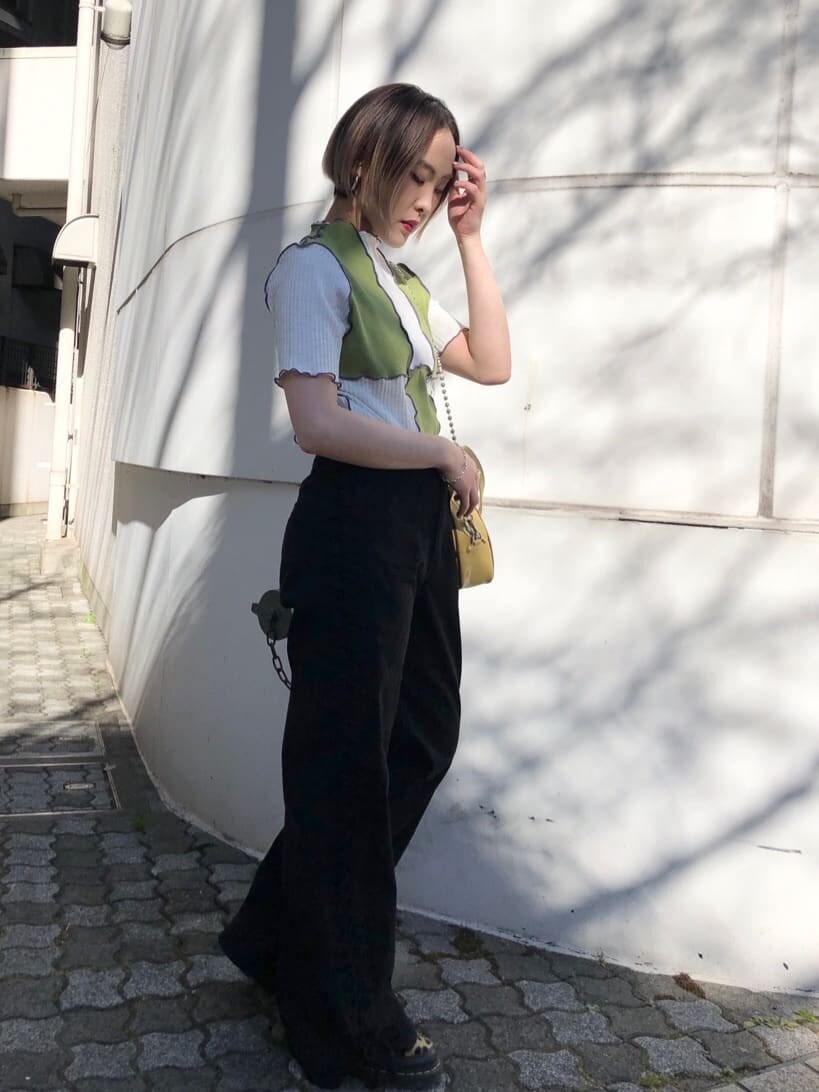 イエロー系のボストンバッグ、ブラック系のデニムパンツ、グリーン系のTシャツ/カットソーを着用したレディースの夏コーディネートの3枚目の写真