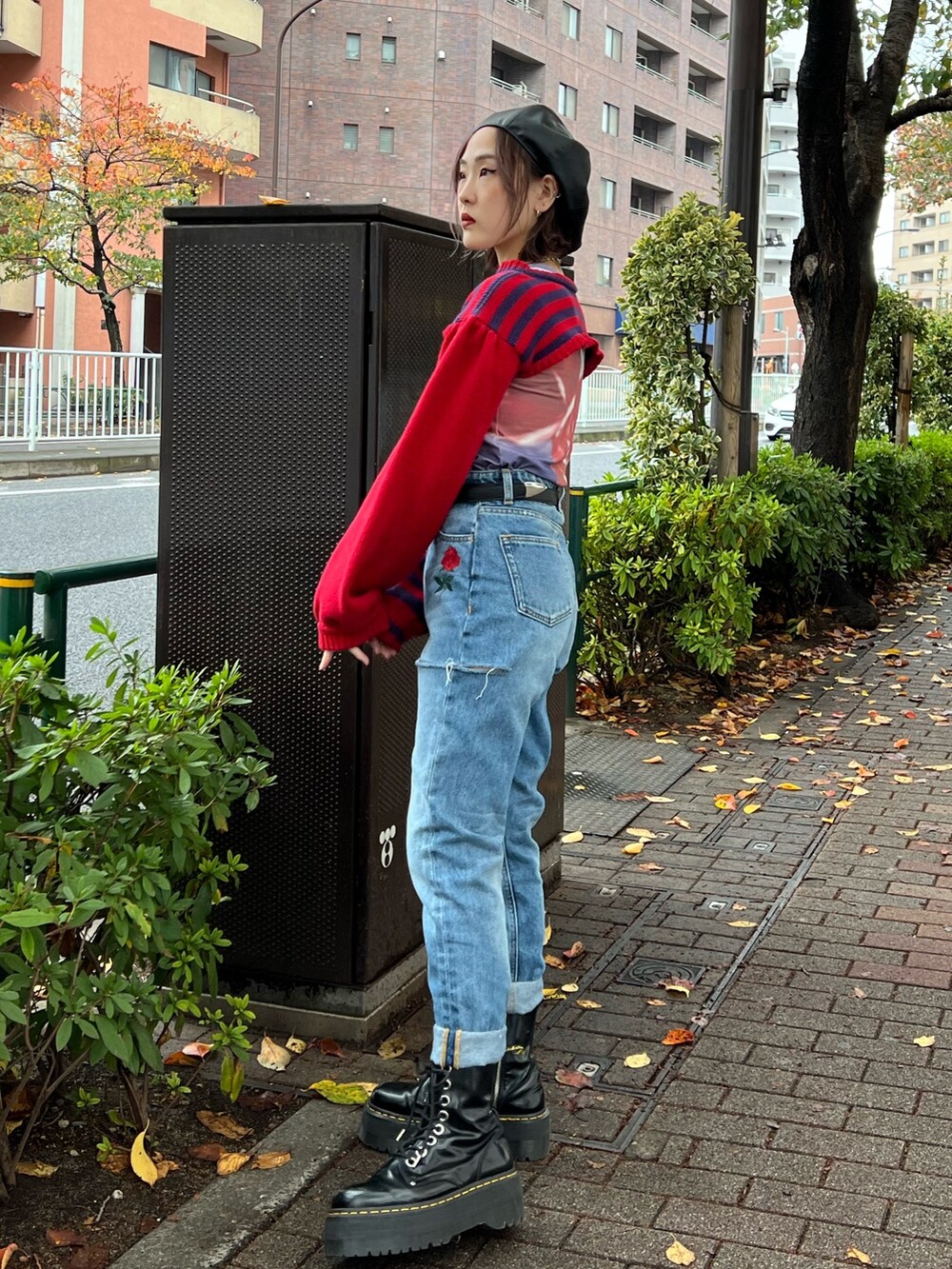 レッド系のニット/セーター、パープル系のTシャツ/カットソー、ブルー系のデニムパンツを着用したレディースの冬コーディネートの10枚目の写真