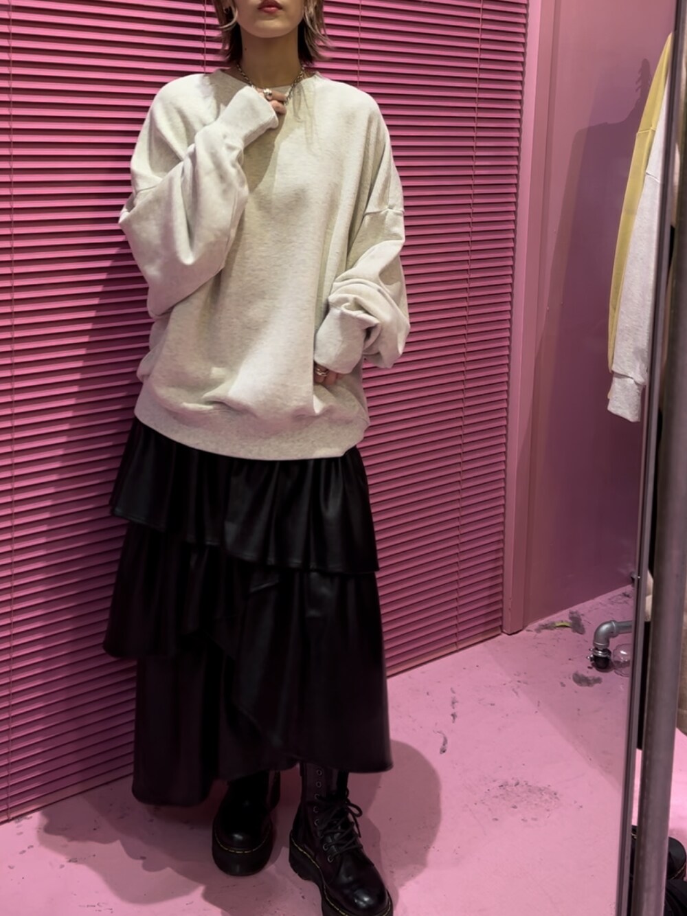 グレー系のTシャツ/カットソー、ブラック系のスカート、ブラック系のブーツを着用したレディースの秋コーディネートの5枚目の写真