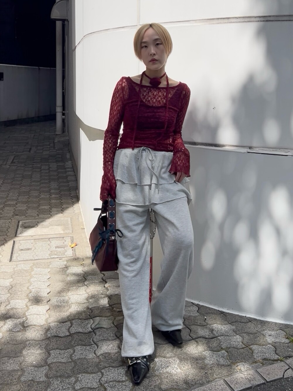 レッド系のTシャツ/カットソー、グレー系のスウェットパンツ、レッド系のハンドバッグを着用したレディースの夏コーディネートの7枚目の写真