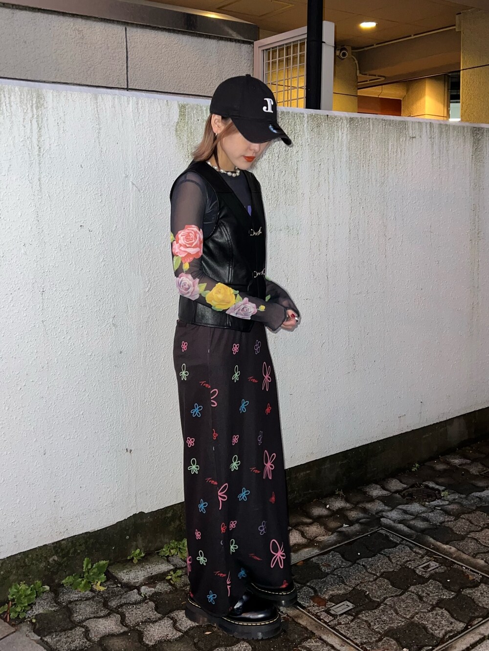 ブラック系のTシャツ/カットソー、ブラック系のベスト、ブラック系のスカートを着用したレディースの春コーディネートの9枚目の写真