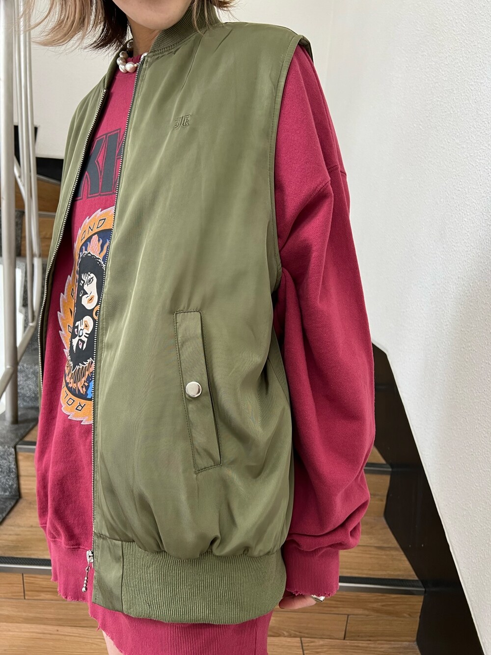 レッド系のスウェット、グリーン系のMA-1、ブラック系のデニムパンツを着用したレディースの冬コーディネートの8枚目の写真