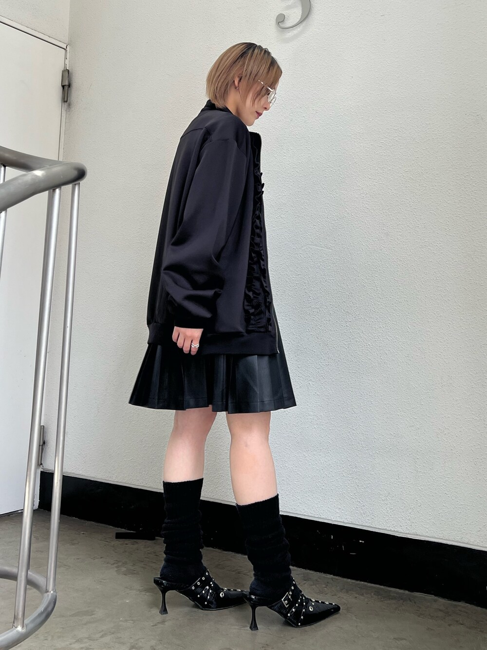 ブラック系のジャージ、ブラック系のパンプス、ブラック系のスカートを着用したレディースの春コーディネートの5枚目の写真